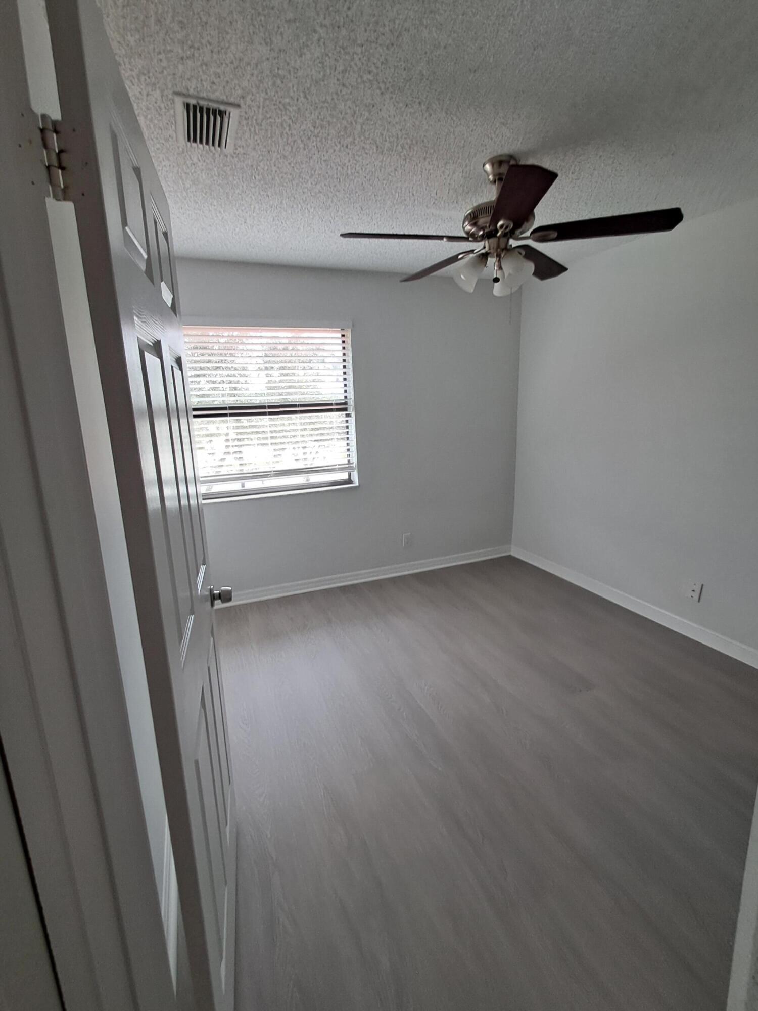 12236 Sag Harbor Court, Unit 4 Wellington, FL 33414 - Photo 10 of 11 a view of a room with a wooden floor and window