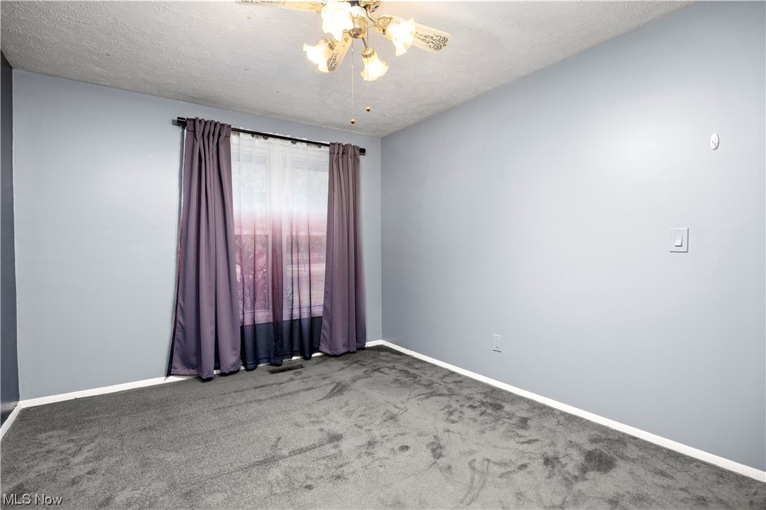 18042 Howe Road Strongsville, OH 44136 - Photo 22 of 35 Unfurnished room with carpet, a textured ceiling, and a notable chandelier