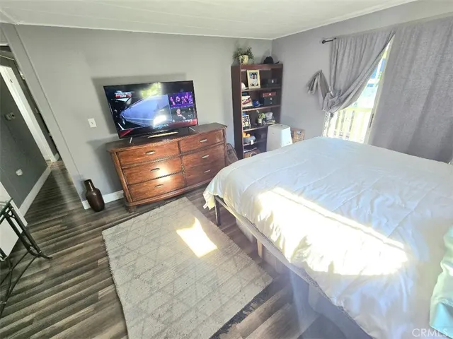 a living room with a bed and a flat screen tv