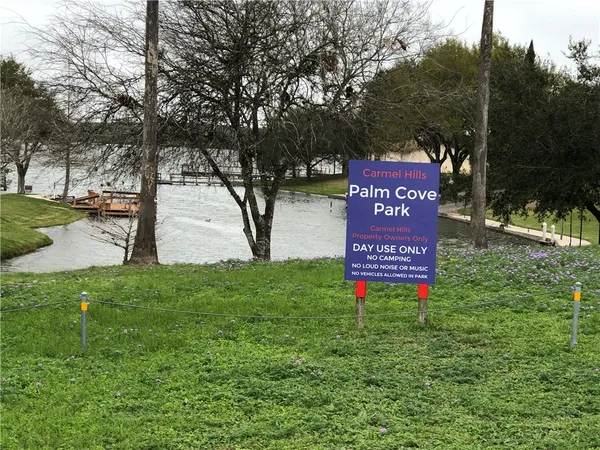 a sign that is sitting in front of a tree