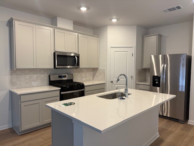 117 Maple Hedge Road Hutto, TX 78634 - Photo 2 of 7 a kitchen with stainless steel appliances a microwave sink refrigerator and cabinets