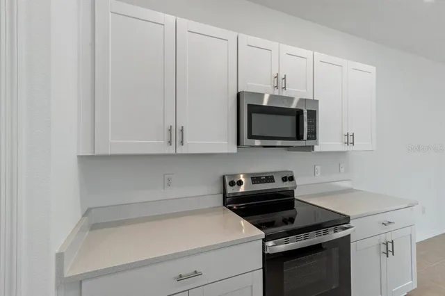 a kitchen with white cabinets and stainless steel appliances