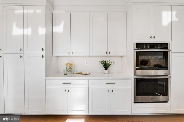 a kitchen with stainless steel appliances white cabinets and a refrigerator