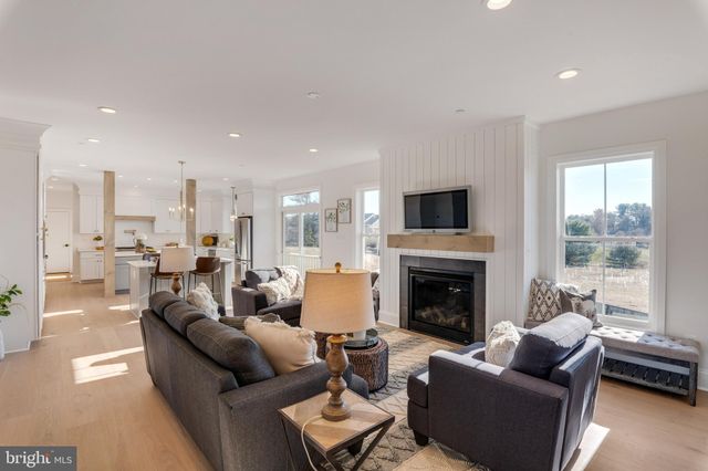 a living room with furniture fireplace and a large window