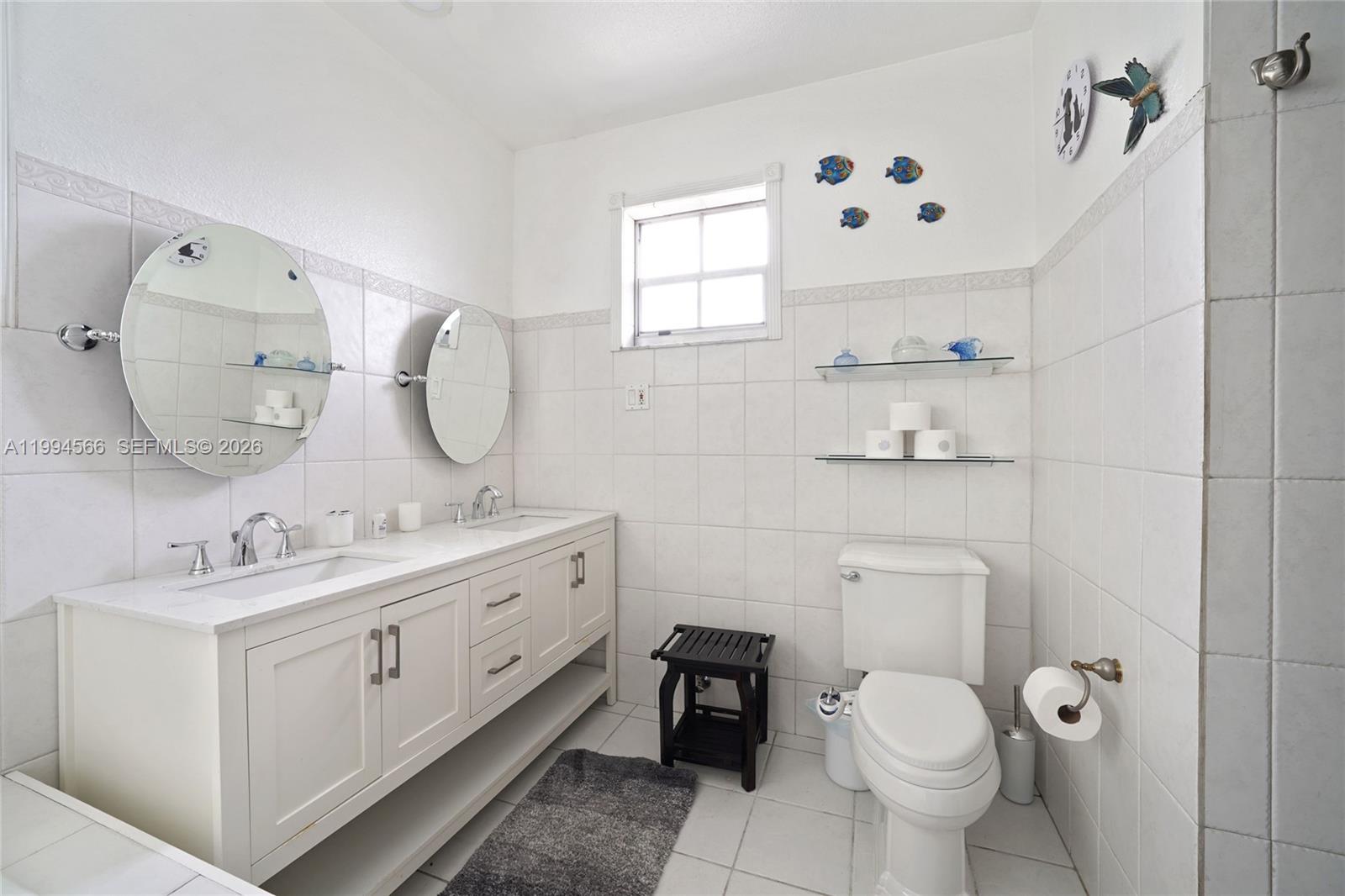 2834 Southwest 33rd Avenue Miami, FL 33133 - Photo 25 of 36 a bathroom with a double vanity sink mirror and toilet
