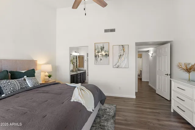 a bedroom with a large bed and wooden floor