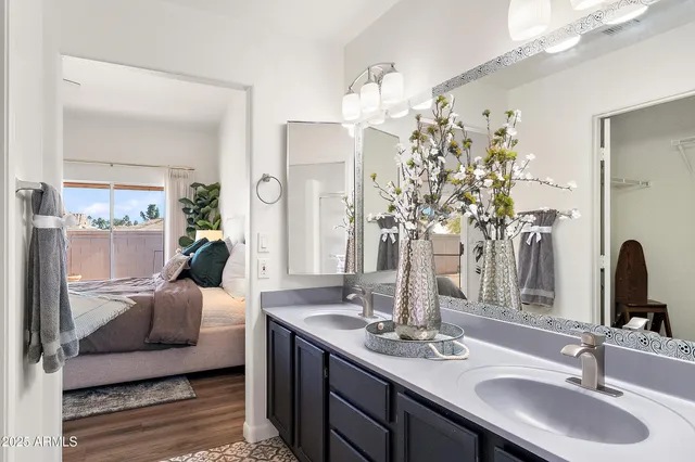 a en suite bathroom with double vanity a mirror and shower