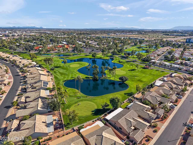 an aerial view of a city with lots of residential buildings and mountain view in back
