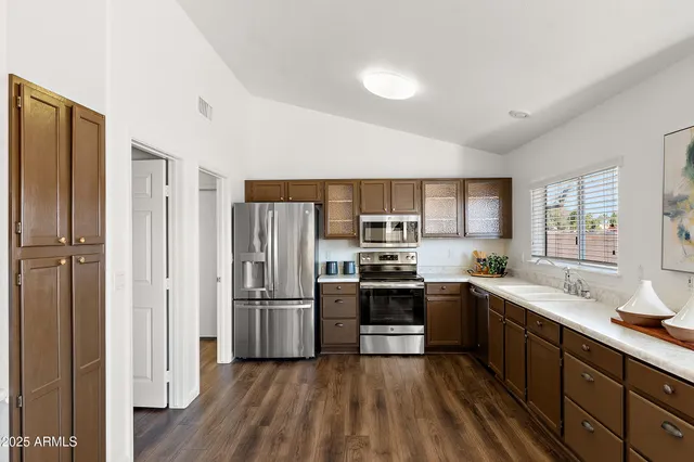 a kitchen with stainless steel appliances granite countertop a refrigerator and a stove top oven
