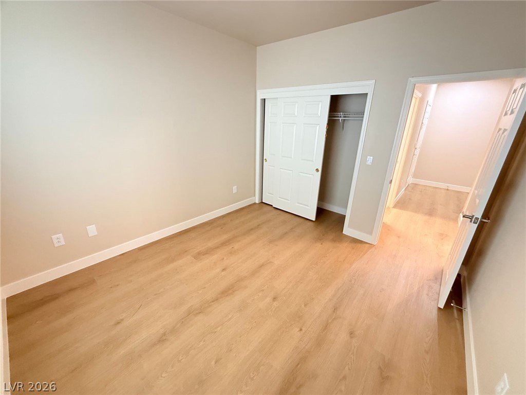 3036 Fort Stanwix Road Henderson, NV 89052 - Photo 13 of 18 Warm wood flooring pairs beautifully with smooth, neutral walls in this versatile bedroom.