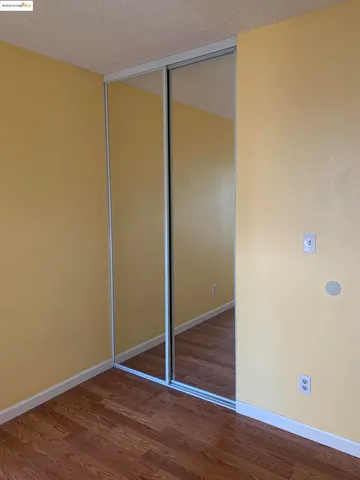 an empty room with wooden floor and closet