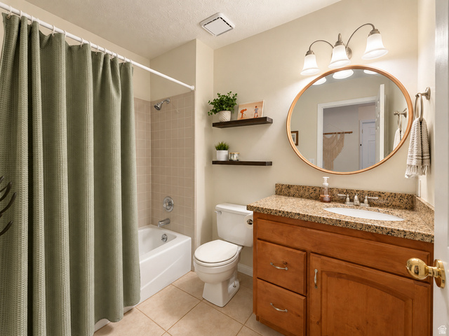 452 North 600 East Springville, UT 84663 - Photo 19 of 26 Bathroom featuring a tile floor, wood-finish vanity with a granite-style countertop, oval mirror, and three-light vanity fixture