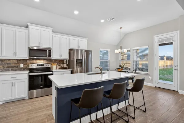 a large kitchen with kitchen island a dining table and chairs