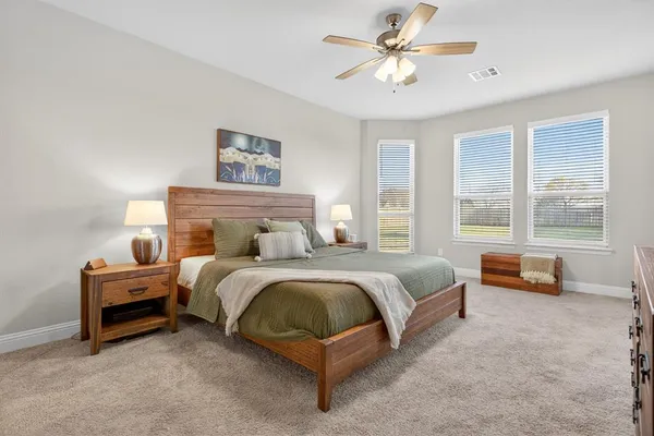 a spacious bedroom with a bed and a large window