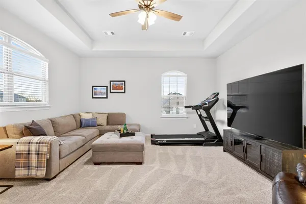 a living room with furniture a flat screen tv and a window