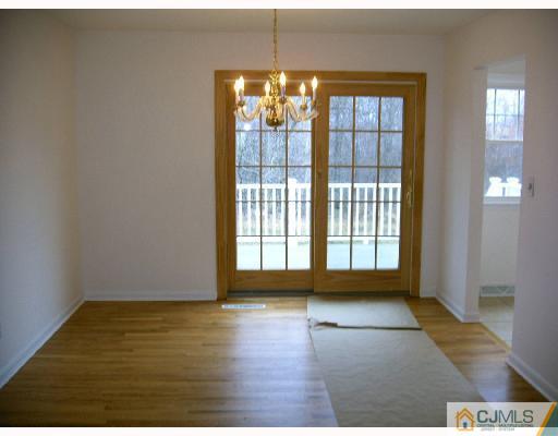 432 Morristown Road Old Bridge, NJ 07747 - Photo 2 of 6 a view of an empty room with glass door and wooden floor