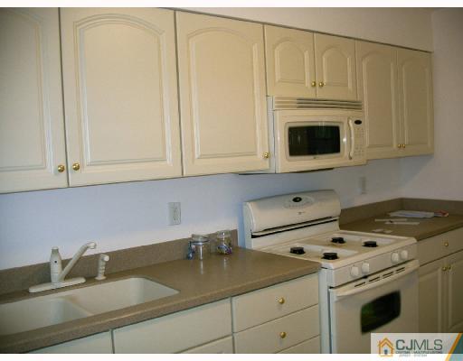 432 Morristown Road Old Bridge, NJ 07747 - Photo 5 of 6 a kitchen with granite countertop a sink a stove and cabinets