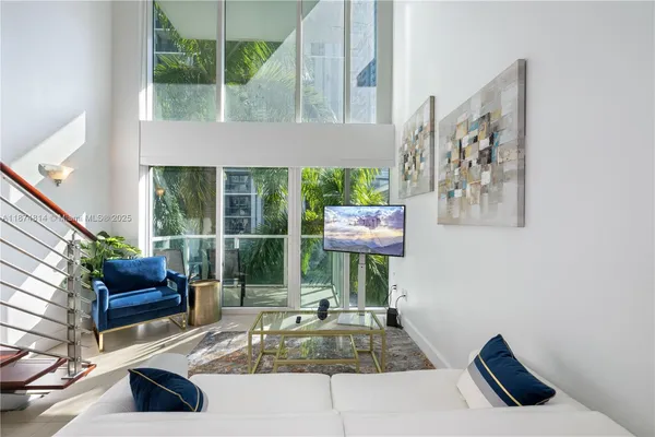 a living room with furniture and a floor to ceiling window