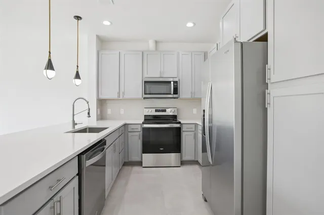 a kitchen with stainless steel appliances granite countertop a refrigerator and a stove top oven