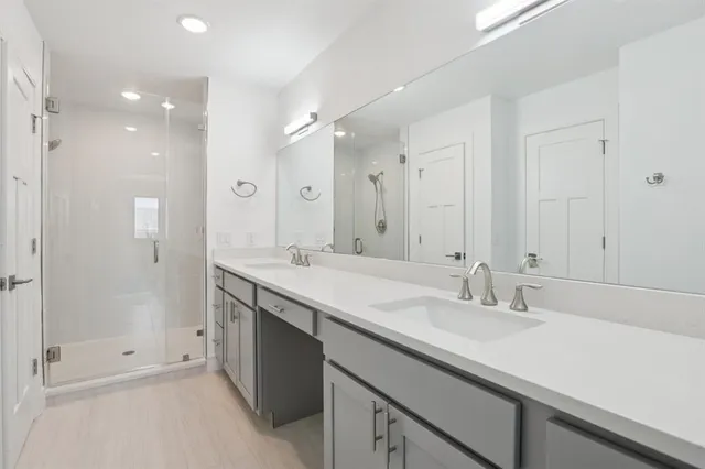 a bathroom with a shower sink double and mirror