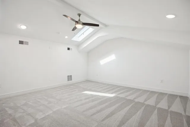an empty room with a ceiling fan and window