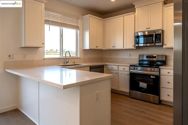 a view of a kitchen with a sink a refrigerator and a stove top oven