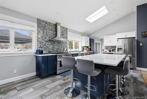a kitchen with granite countertop a table chairs a sink dishwasher refrigerator and cabinets
