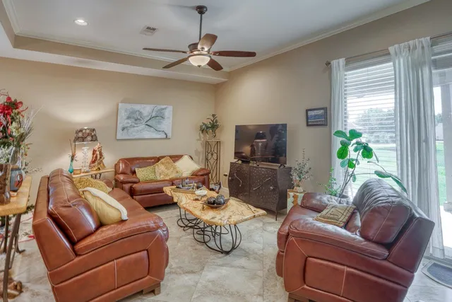 a living room with furniture ceiling fan and a window