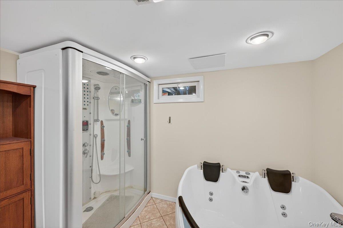 188 Donegan Avenue East Patchogue, NY 11772 - Photo 14 of 25 a bathroom with a tub and shower