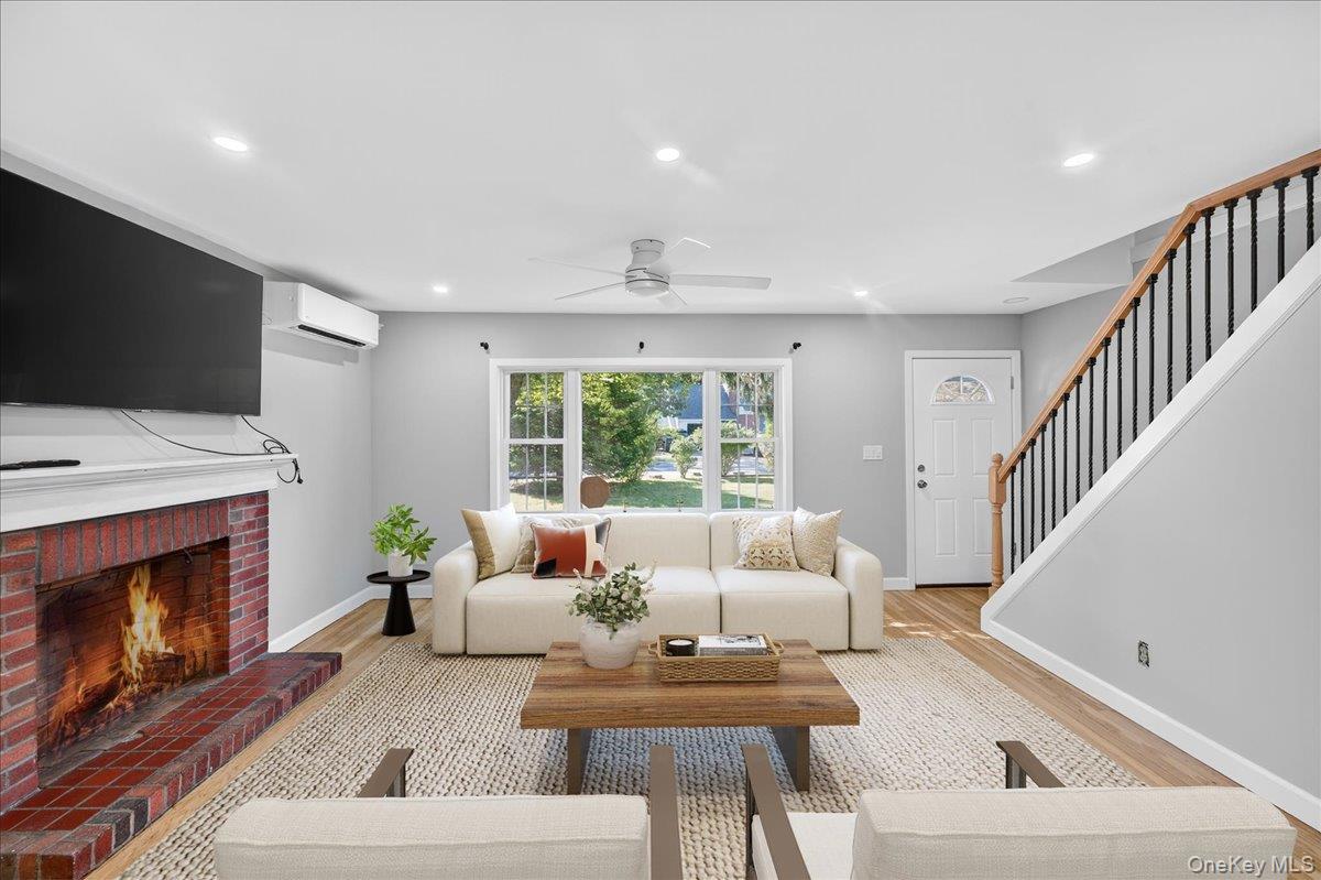 188 Donegan Avenue East Patchogue, NY 11772 - Photo 2 of 25 a living room with furniture a fireplace and a flat screen tv