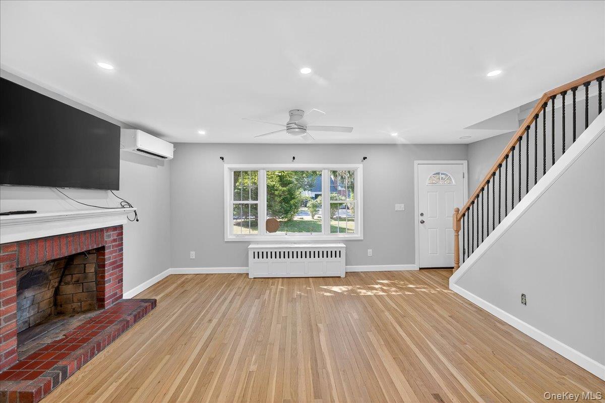 188 Donegan Avenue East Patchogue, NY 11772 - Photo 23 of 25 a view of an empty room with wooden floor fireplace and a window