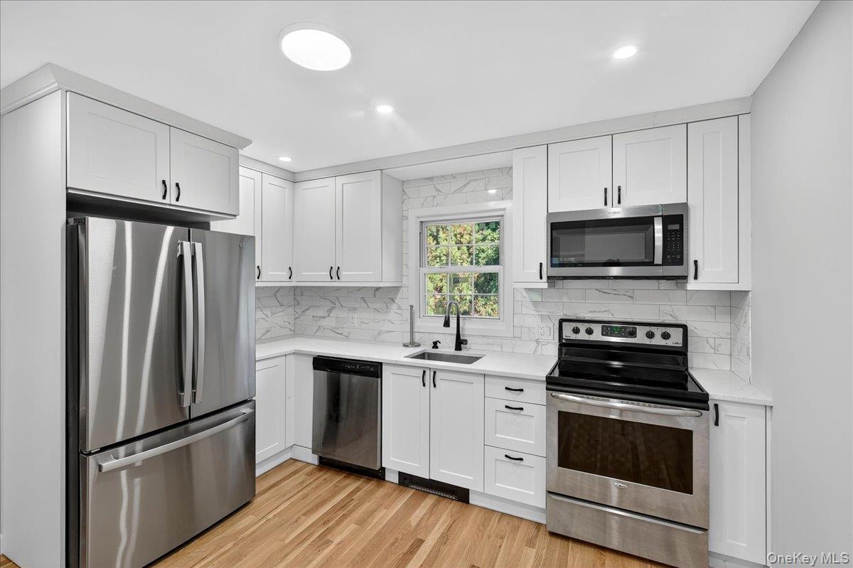 188 Donegan Avenue East Patchogue, NY 11772 - Photo 5 of 25 a kitchen with a sink stainless steel appliances and cabinets