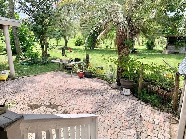 a view of backyard of house with outdoor seating and trees