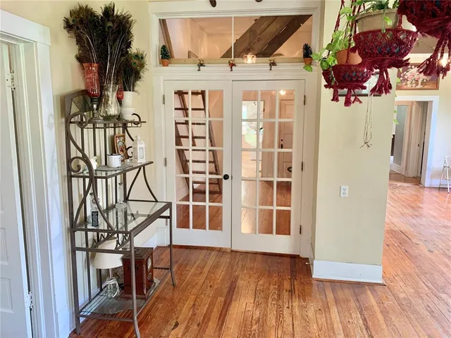 a view of a refrigerator in kitchen and an empty room