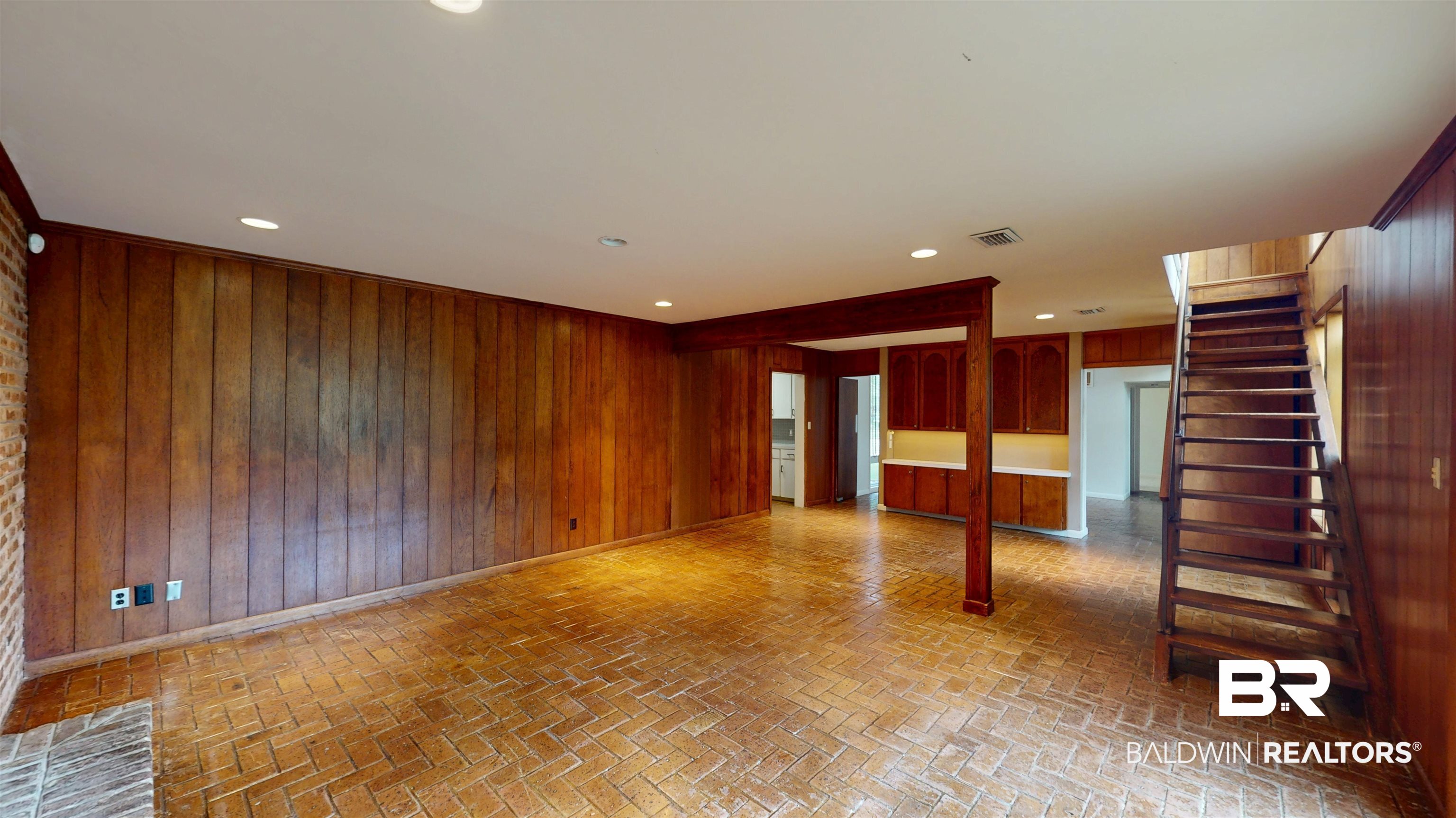 15 Spring Bank Road Mobile, AL 36608 - Photo 18 of 58 Unfurnished room featuring wooden walls, brick floors, stairs, and recessed lighting