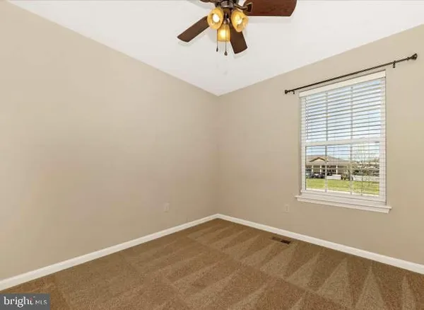 an empty room with chandelier fan