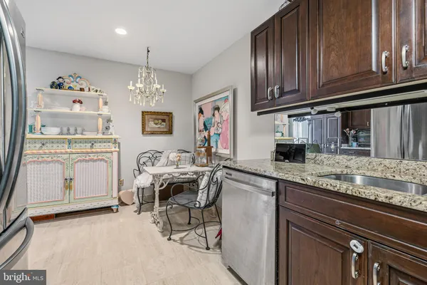 a kitchen with stainless steel appliances granite countertop a sink cabinets and wooden floor