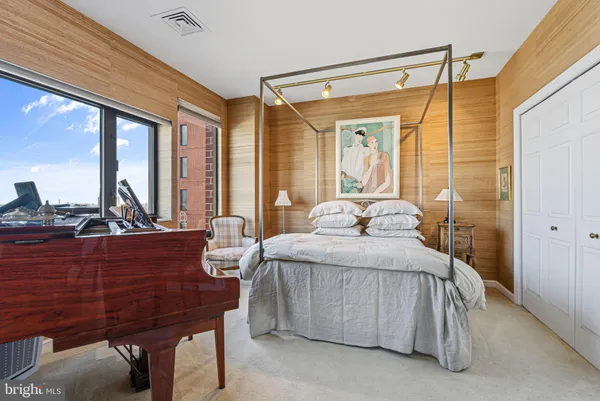 a bedroom with a bed and large windows