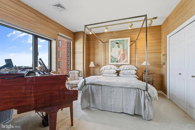 a bedroom with a bed and large windows