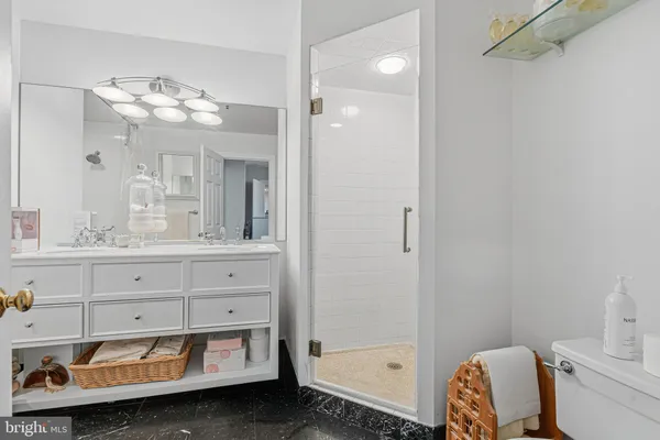 a bathroom with a sink mirror and a shower