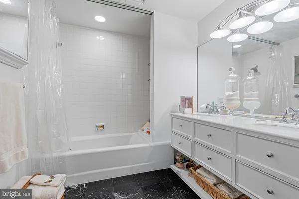 a bathroom with a tub sink and mirror