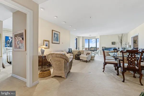a living room with furniture and a dining table with chairs