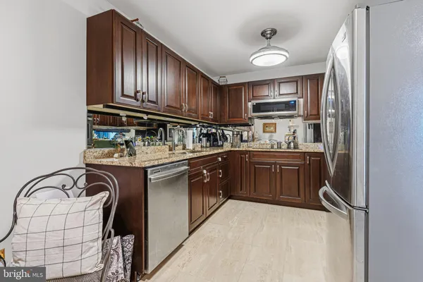 a kitchen with stainless steel appliances granite countertop a sink a stove and cabinets
