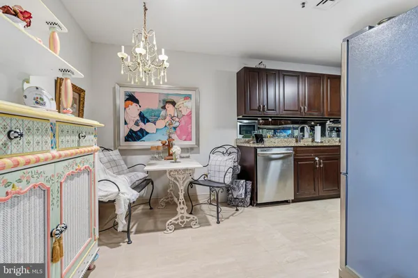 a view of a kitchen with kitchen island granite countertop furniture a stove and a chandelier