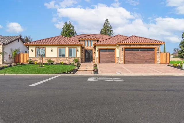 a front view of a house with a yard and garage