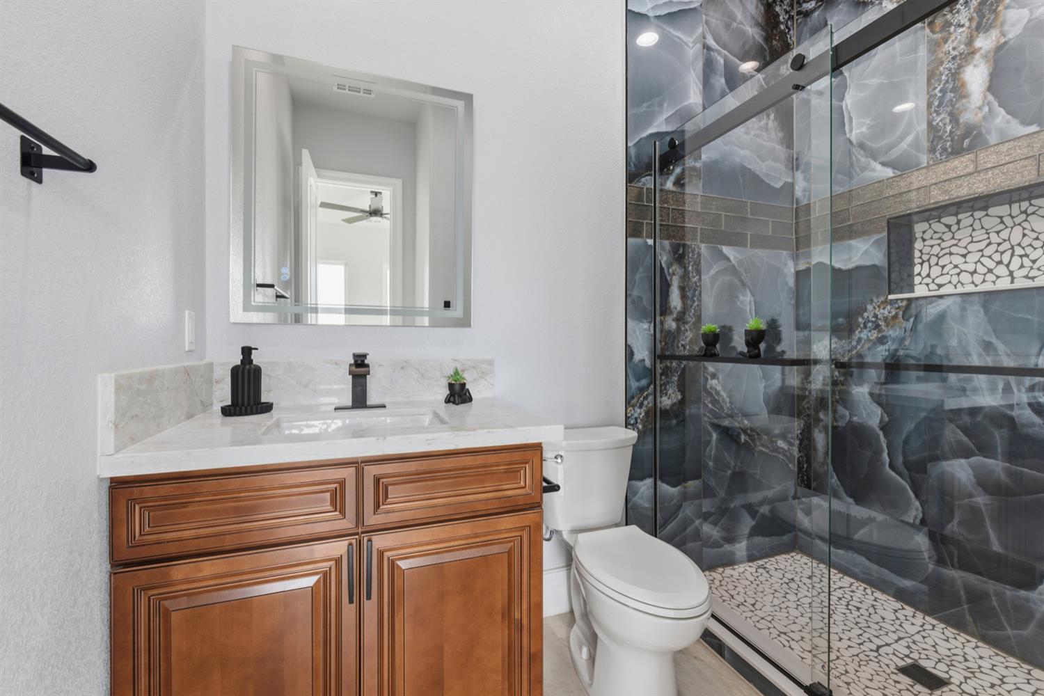 2009 Robin Hood Lane Merced, CA 95340 - Photo 38 of 50 a bathroom with a granite countertop toilet sink and mirror