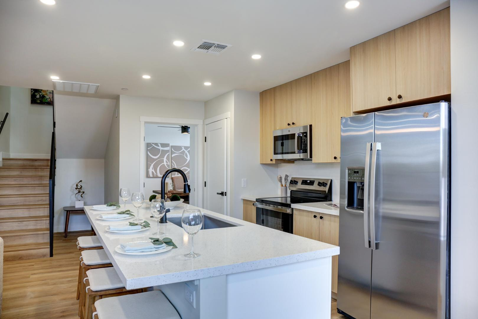 630 North Power Road, Unit 111 Mesa, AZ 85205 - Photo 6 of 13 a kitchen with stainless steel appliances kitchen island granite countertop a refrigerator a sink a stove with a dining table and chairs