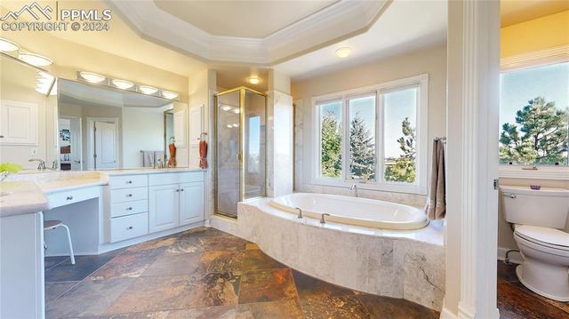 a spacious bathroom with a granite countertop tub toilet a sink and a large mirror