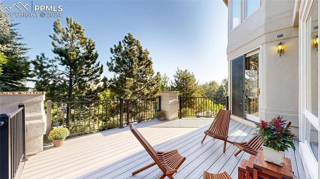 a view of a balcony with chairs and wooden floor