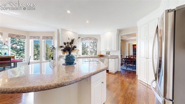 a kitchen view with granite countertop a refrigerator a stove and wooden floor